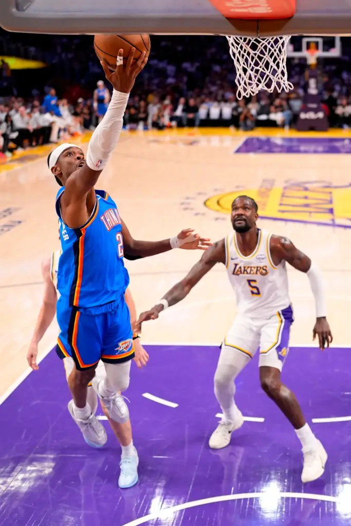 Oklahoma City Thunder guard Shai Gilgeous-Alexander, left, shoots as Lakers...