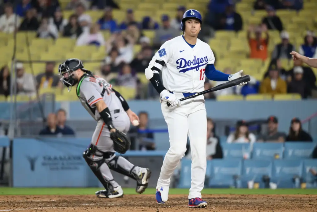 Dodgers star Shohei Ohtani walks back to the dugout after...