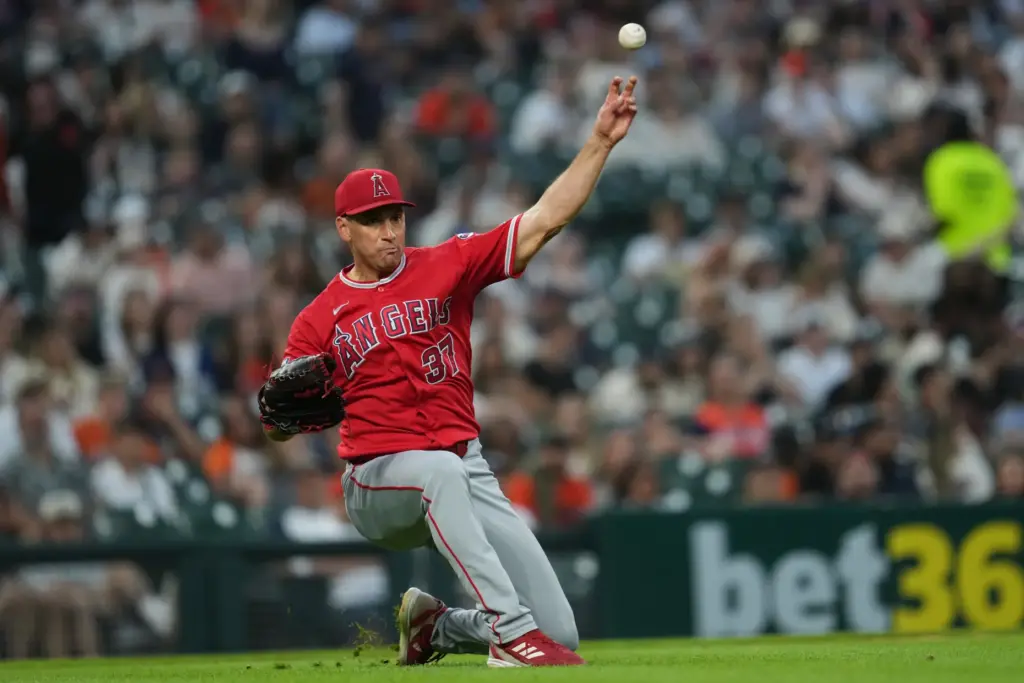 Angels relief pitcher Brent Suter throws to first base after...
