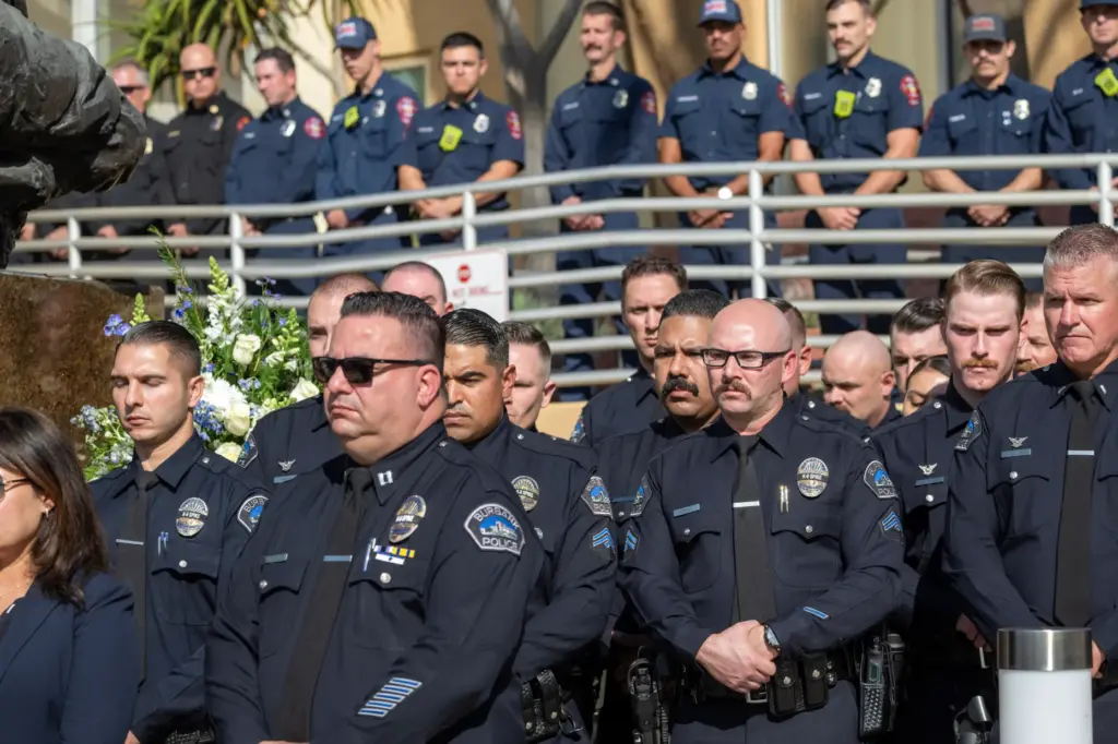 Members of the Burbank Police Department listen to speakers during...