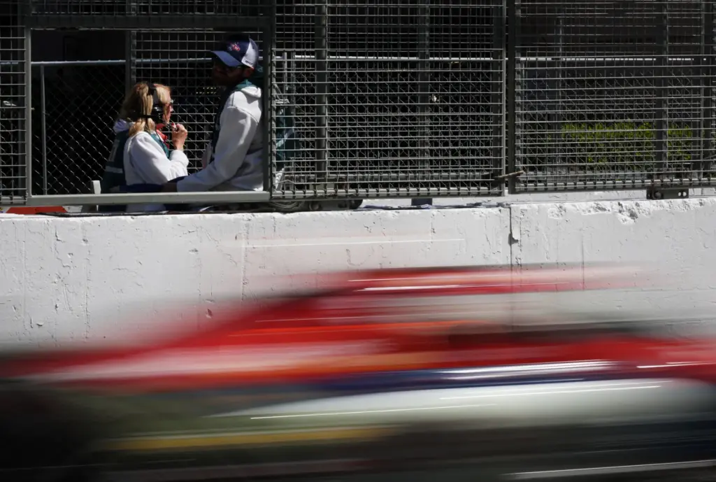 Trackside workers watch the second practice session for the NTT...
