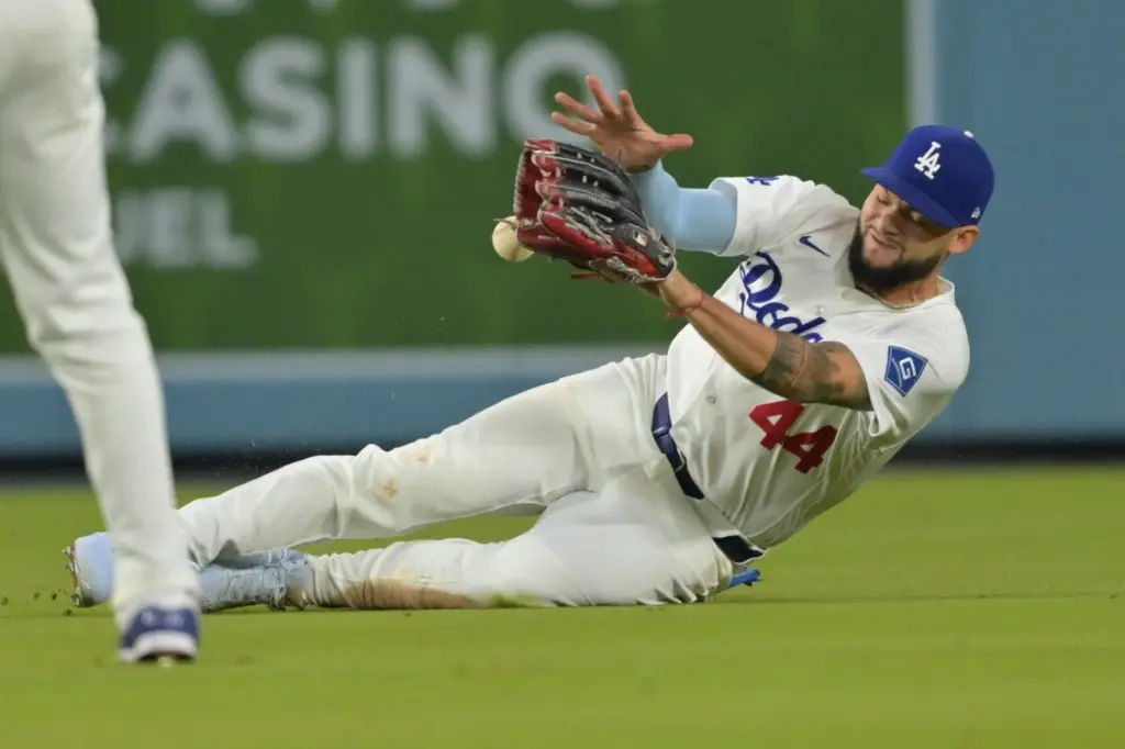 Dodgers center fielder Andy Pages slides as he makes a...
