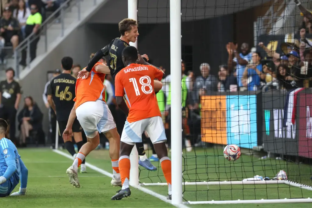 LAFC forward Nathan Ordaz, top, jumps in the air after...