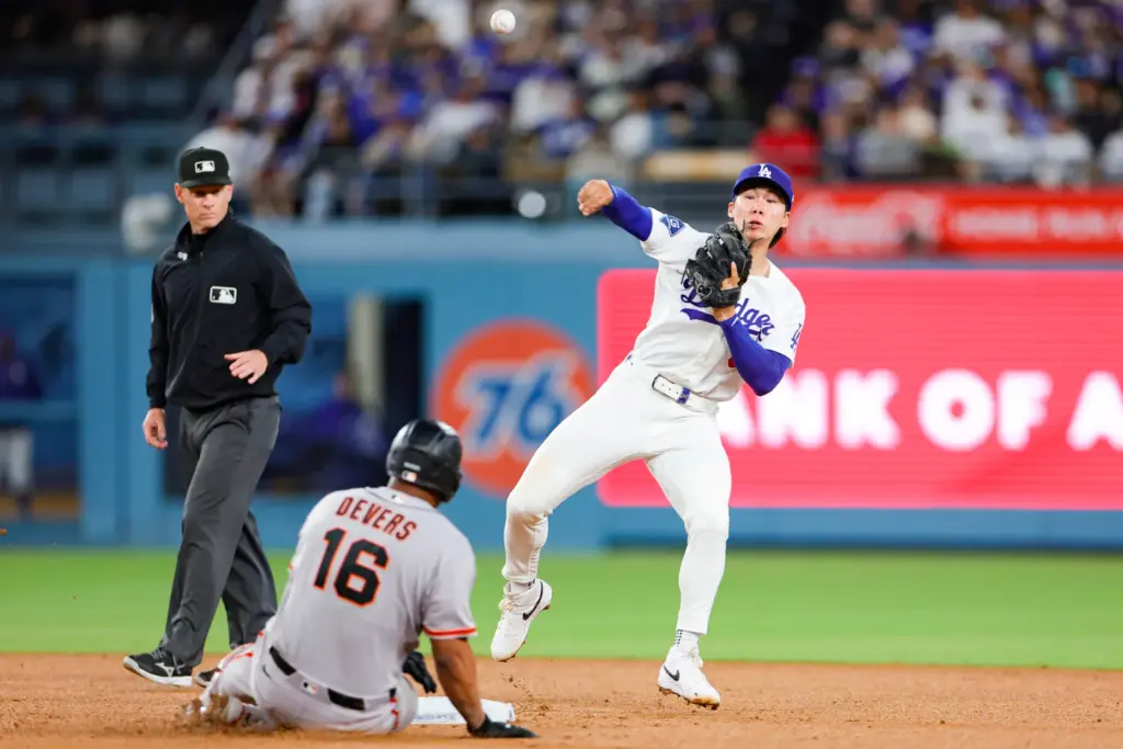 Dodgers second baseman Hyeseong Kim, right, attempts to throw out...