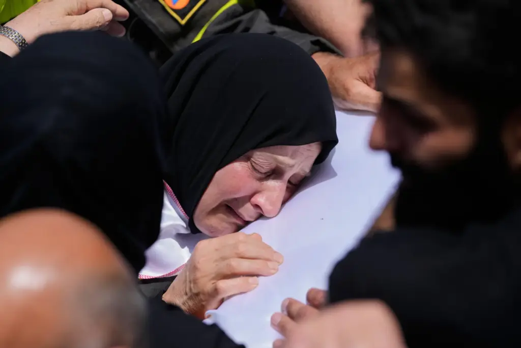 A mourner reacts over the coffin of Lebanese Civil Defense...