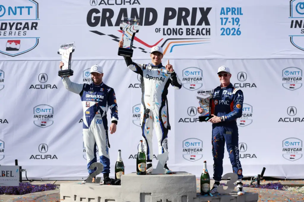 Winning Indycar driver Alex Plaou, center, celebrates alongside second place...