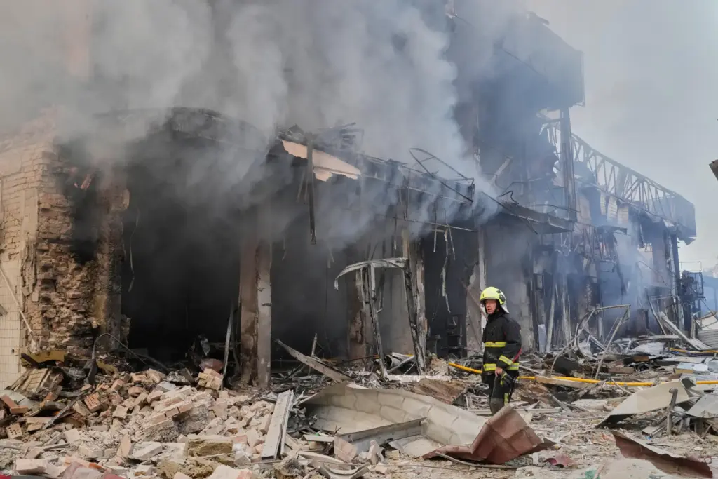 A firefighter tries to extinguish a blaze at a commercial building hit by a Russian attack.