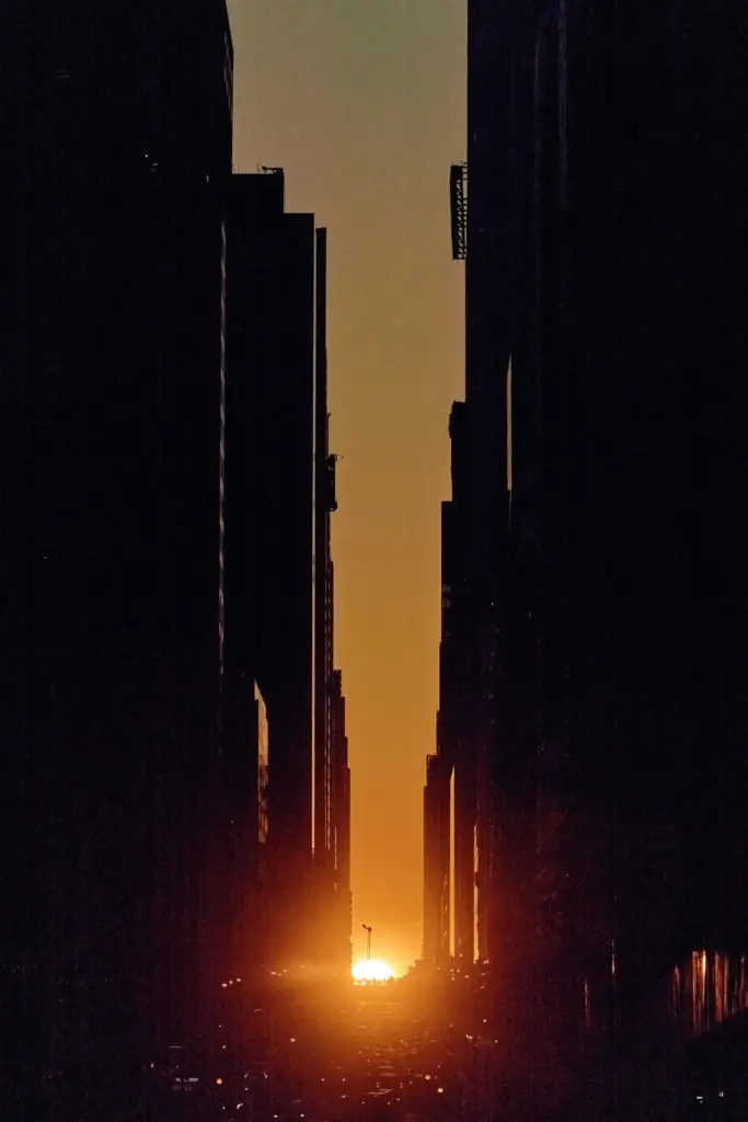 The setting sun is framed between buildings during Manhattanhenge.