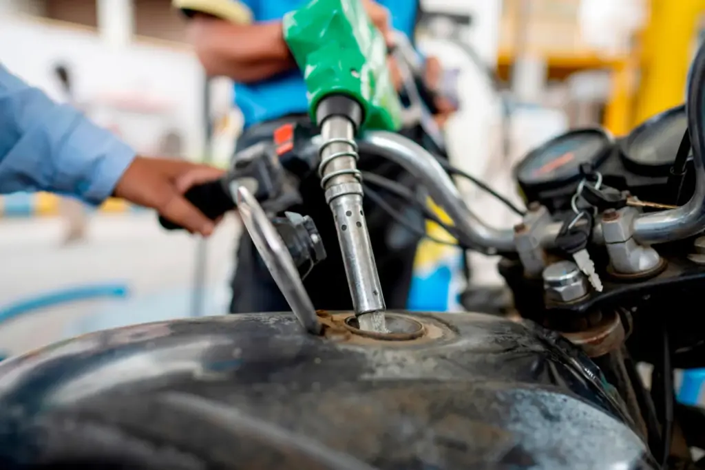 A man fills petrol in a two wheeler at a fuel pump in Prayagraj.
