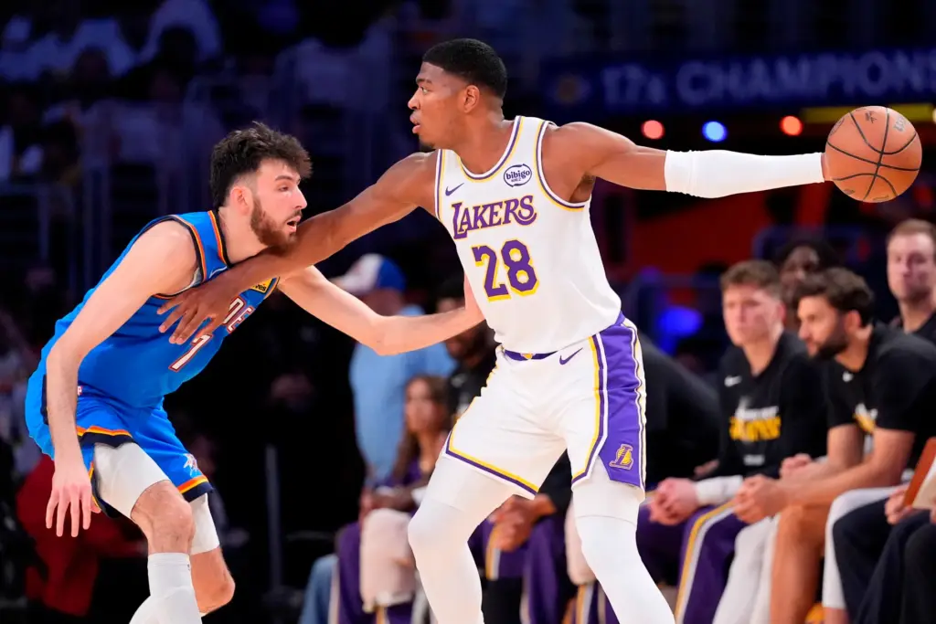 Lakers forward Rui Hachimura, right, looks to pass the ball...