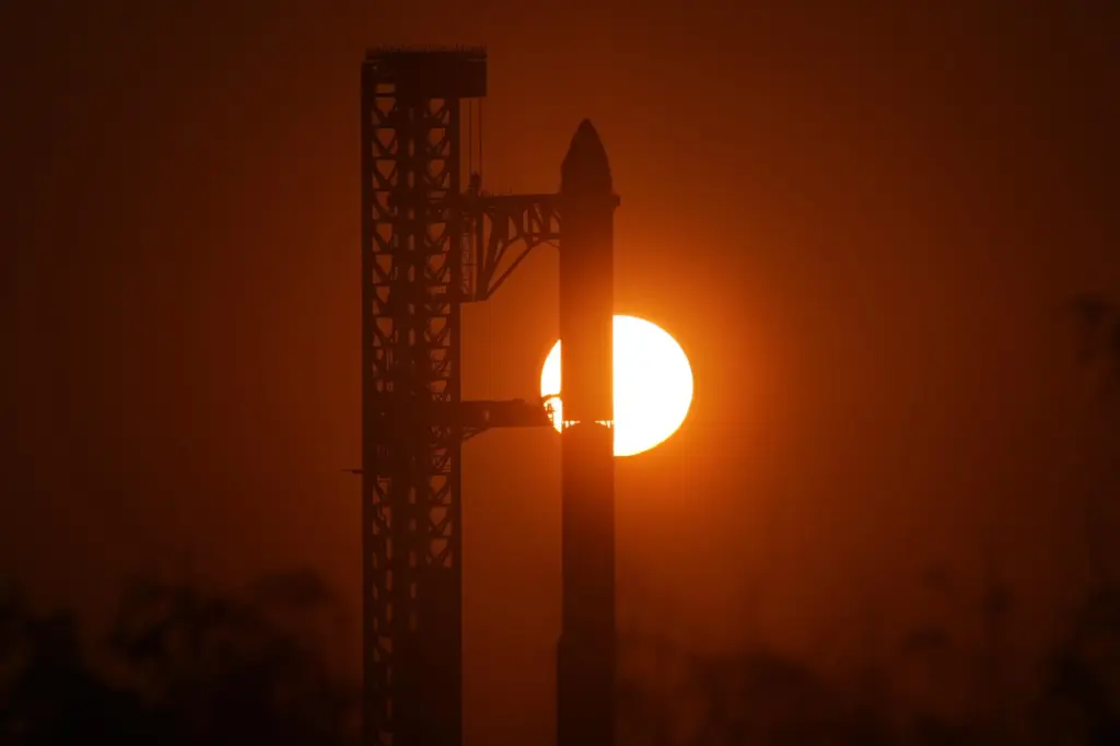 The sun rises behind SpaceX’s mega rocket Starship as it...
