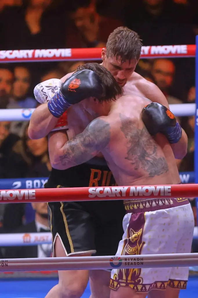 Oleksandr Usyk, front, battles Rico Verhoeven, back, during a boxing...