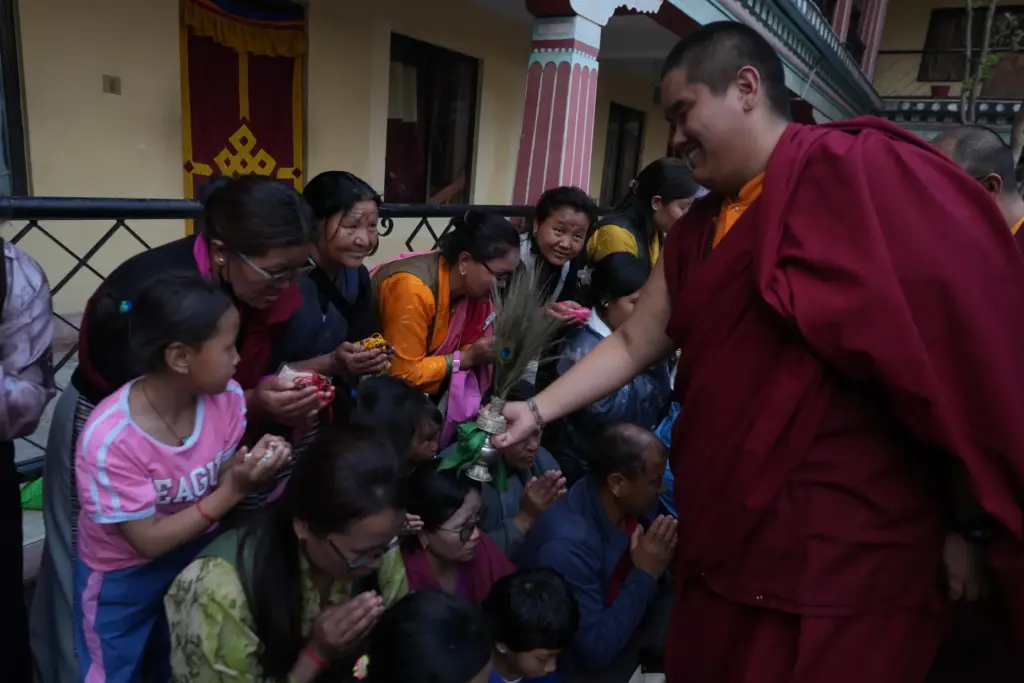 U.S.-born Buddhist lama Jalue Dorje smiles as he blesses people...