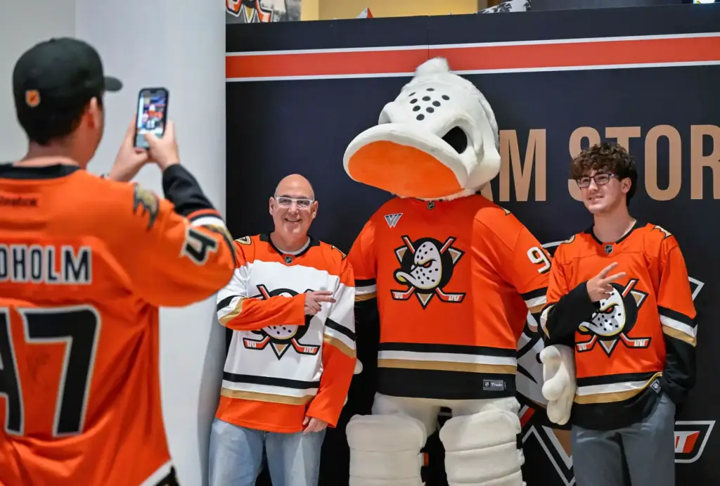 Fans pose for photos with a stuffed Wild Wing mascot...