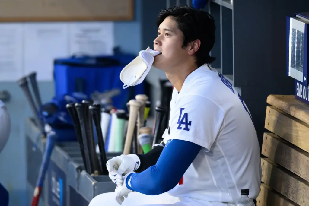 Dodgers star Shohei Ohtani takes his batting gloves off as...