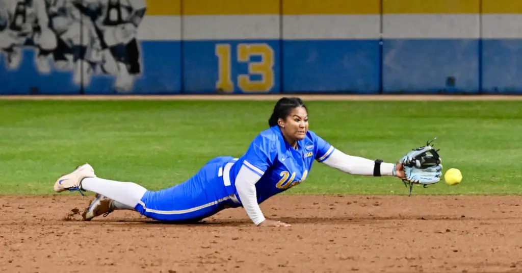 Second baseman Kaniya Bragg #33 of the UCLA Bruins dives,...