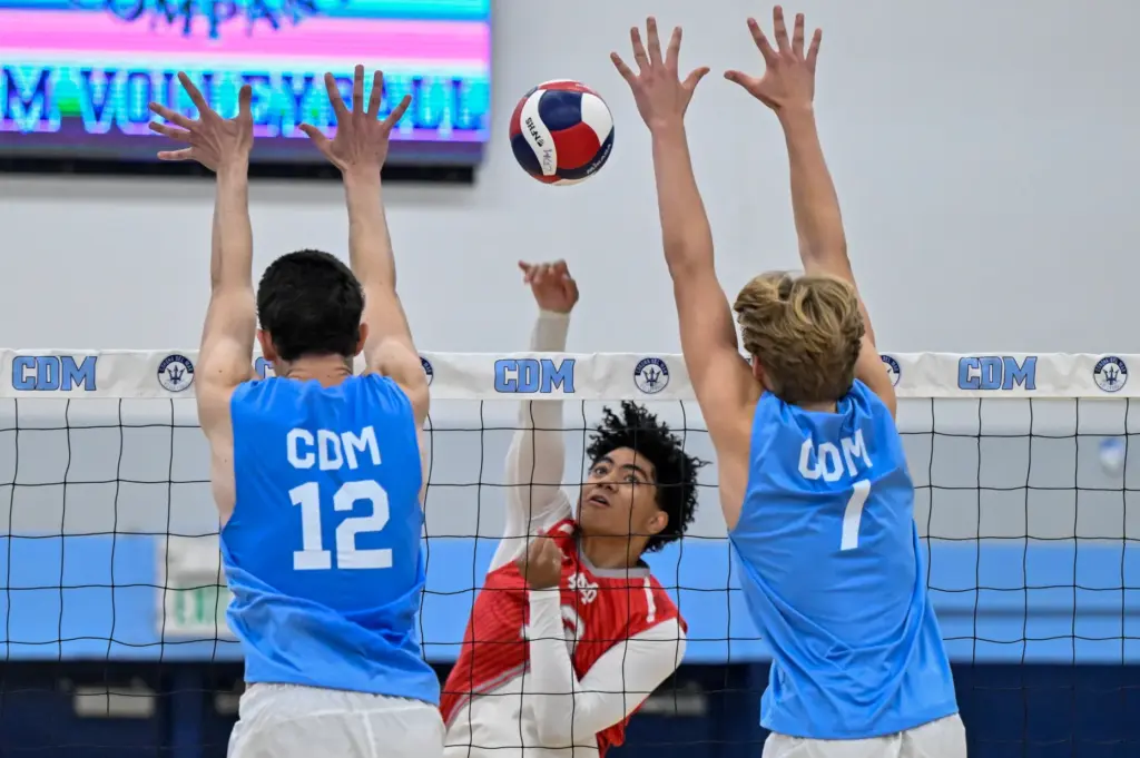 Mater Dei outside hitter Jeremiah Potasi hits the ball through...