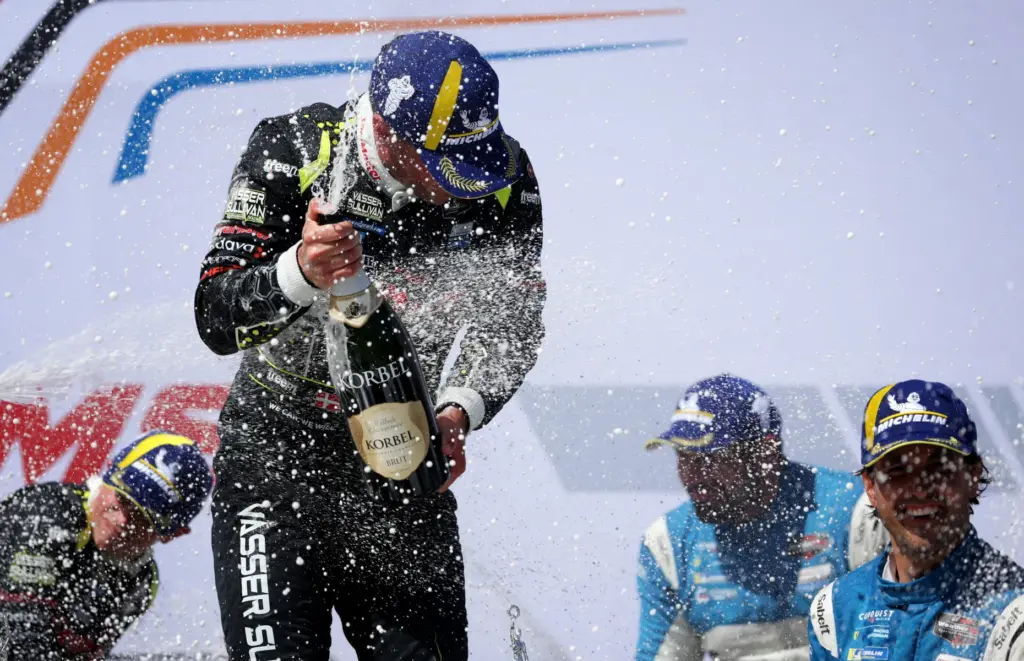 Vasser Sullivan Racing driver Benjamin Pedersen, center left, celebrates after...