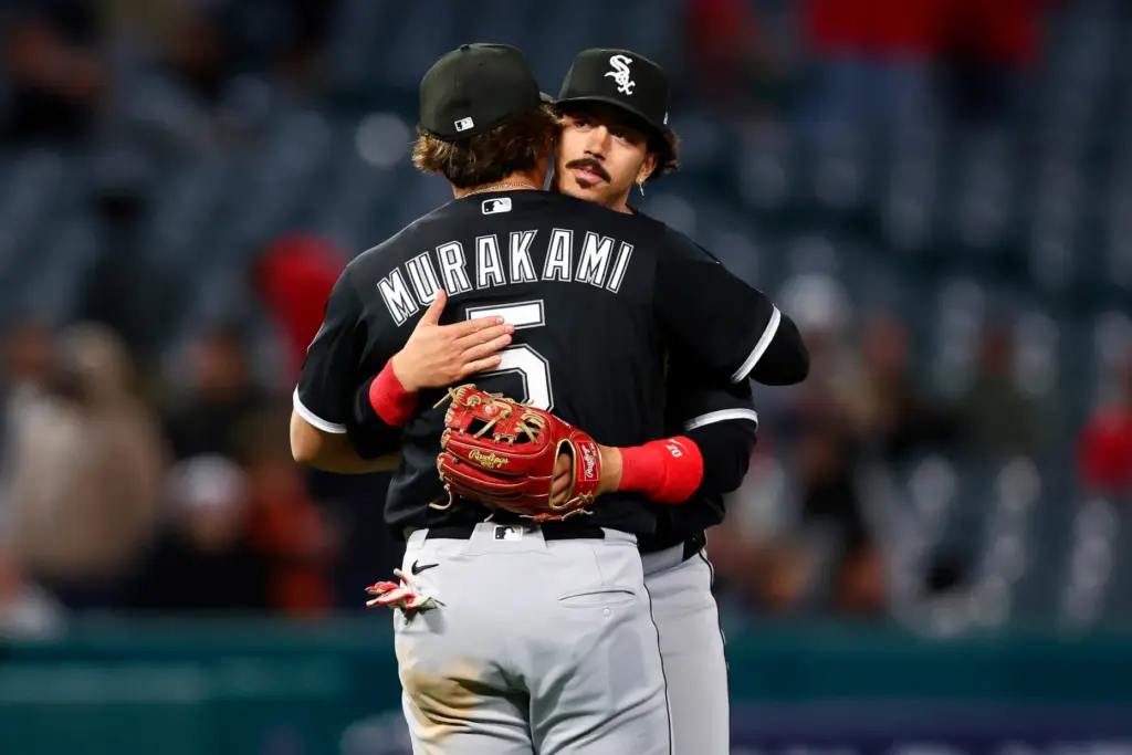 Chicago White Sox third baseman Miguel Vargas, back, and first...