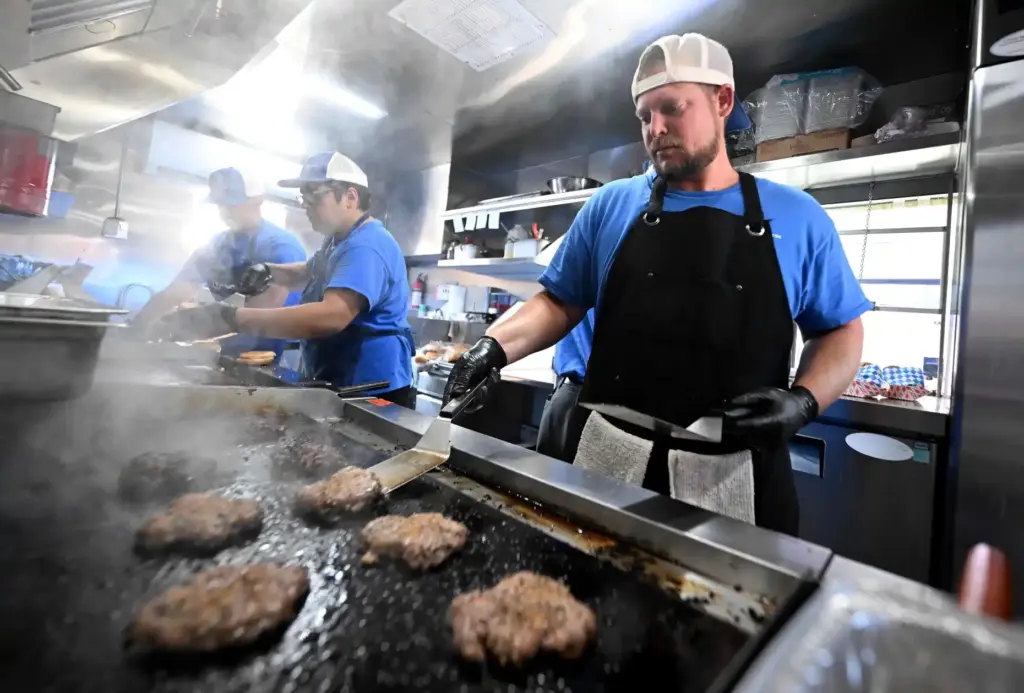 River’s Edge Ranch ârancherâ Alex Rice, 36, cooks smash burgers...
