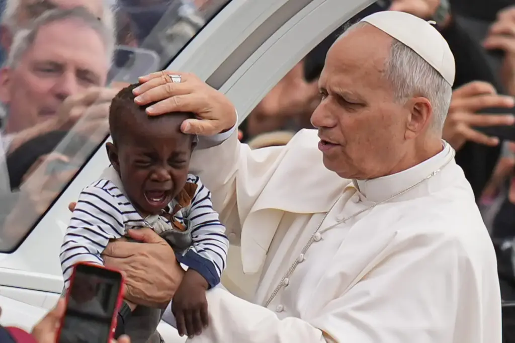 Pope Leo XIV blesses a child