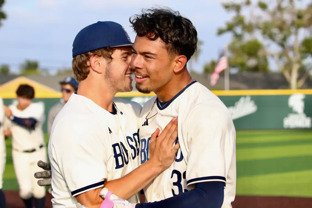 St. John Bosco’s Moises Razo, right, gets a hug from...