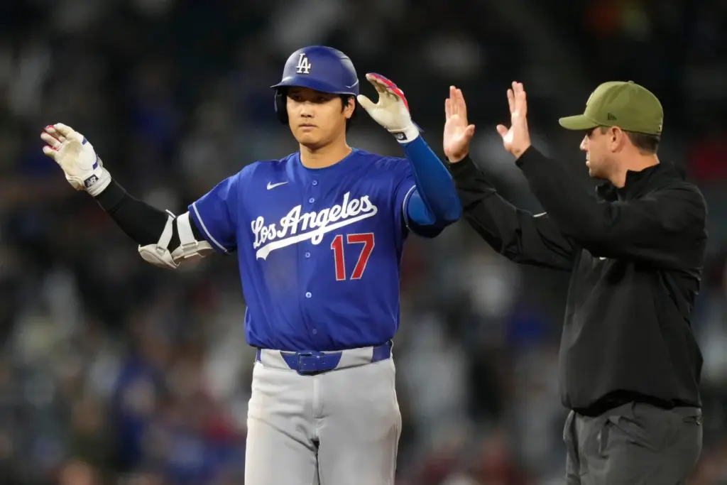 Dodgers’ Shohei Ohtani, left, gestures after hitting an RBI double...