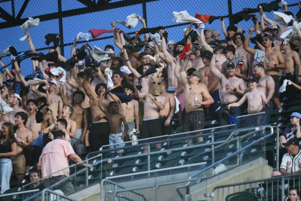 Fans cheer with their shirts off during the eighth inning...