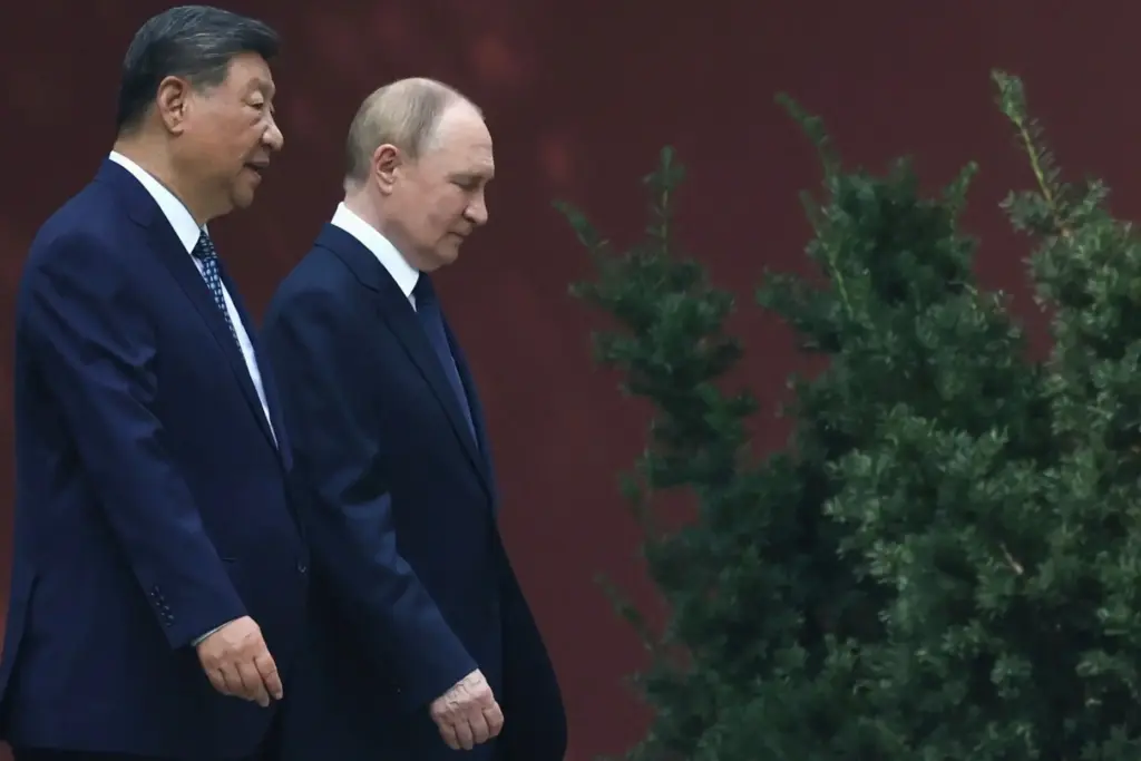 Russian President Vladimir Putin speaks with Chinese President Xi Jinping during a walk.