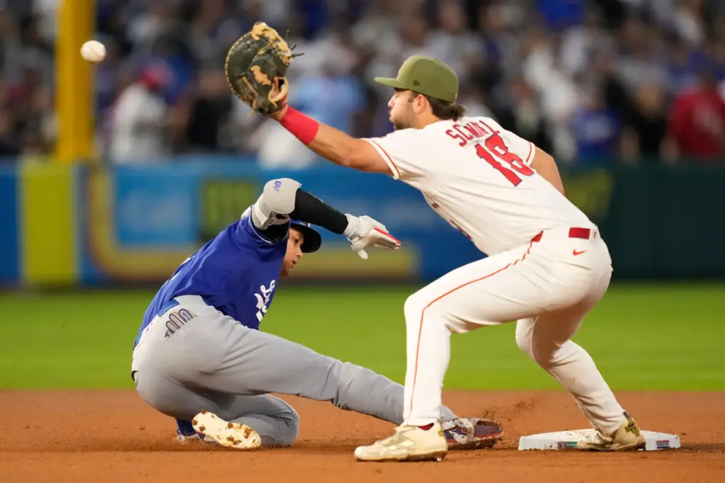 Dodgers star Shohei Ohtani, left, slides back to second base...