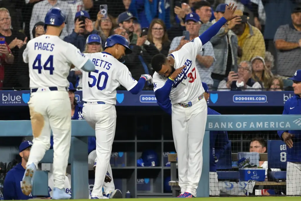 The Dodgers’ Mookie Betts (50) is greeted by teammate Teoscar...