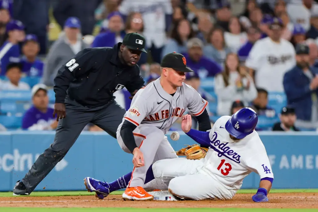 The Dodgers’ Max Muncy, right, reaches third safely as San...