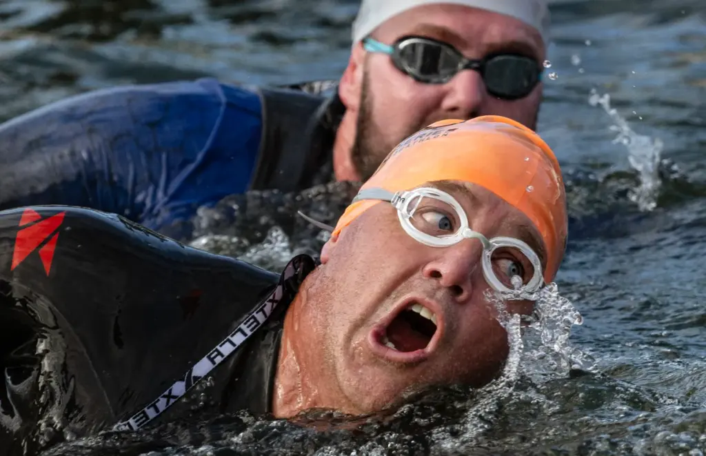 Two swimmers are neck and neck as they finish off...