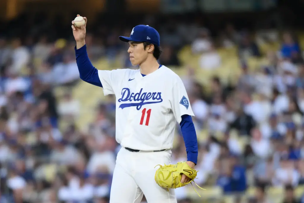 Dodgers starting pitcher Roki Sasaki gestures to a teammate during...