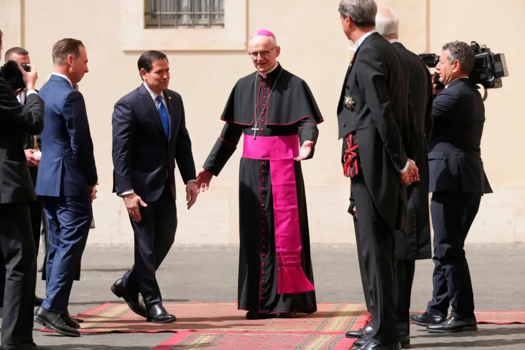 Secretary of State Marco Rubio is greeted by a Vatican official as he arrives at the St. Damasus courtyard.