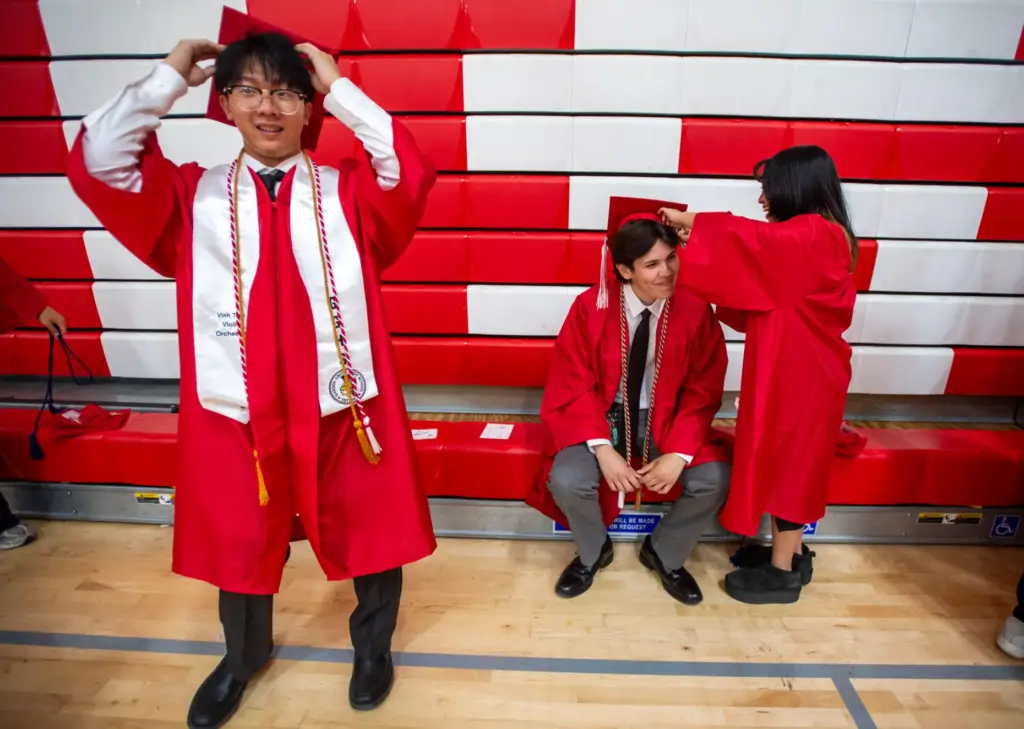 Vinh Tran adjusts his cap as Jenna Nguyen secures Aiden...