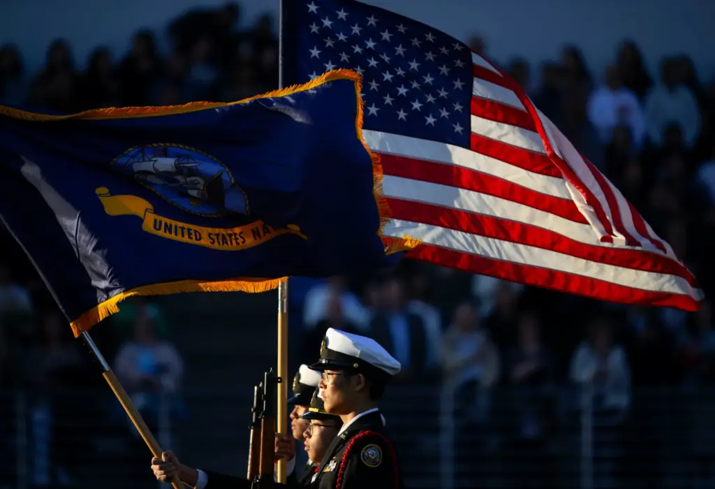Troy Navy JROTC cadets present the colors for the playing...