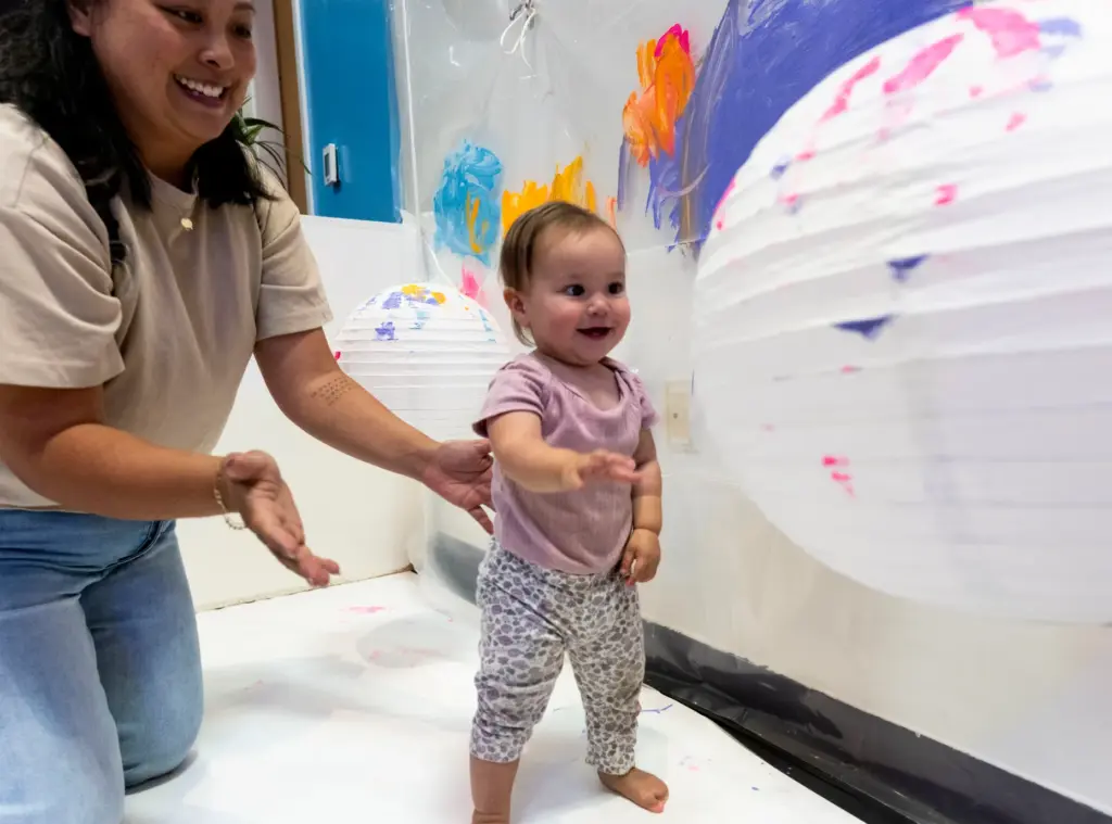 Mila Armstrong, 15 months, plays with paper lanterns with her...