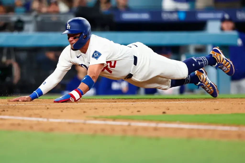 The Dodgers’ Miguel Rojas slides home to score the go-ahead...