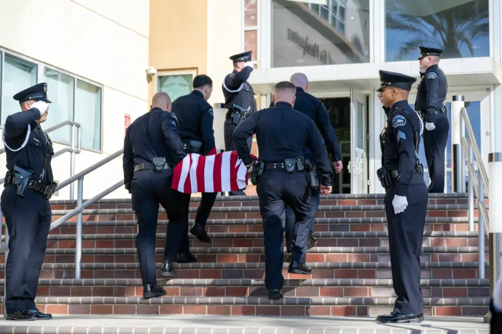 Officers carry the body of Burbank Police K-9 Spike during...