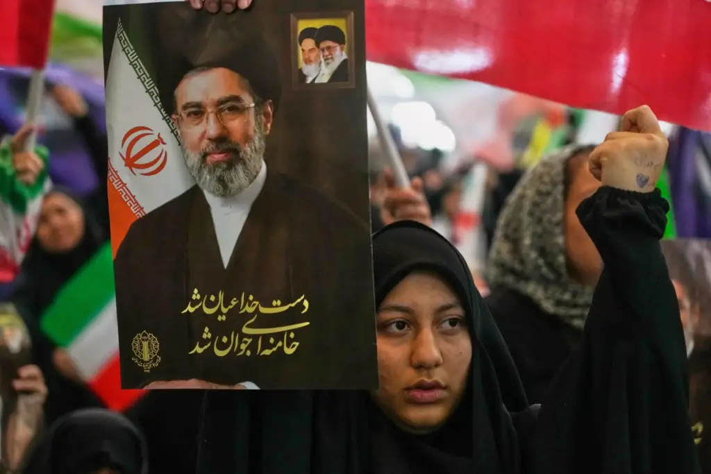 A woman holds a portrait of Iran’s Supreme Leader, Ayatollah...