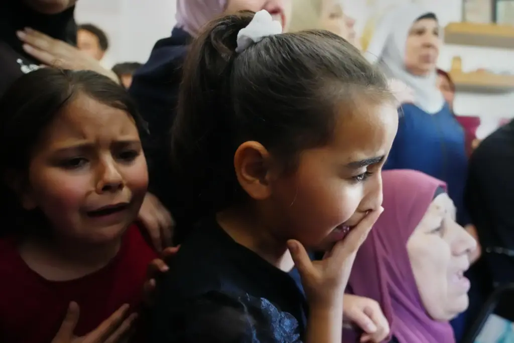 Children cry while they take the last look at the...