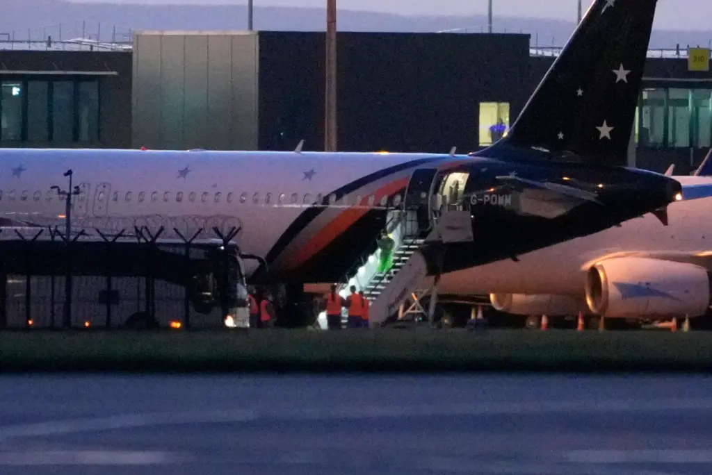 Passengers leave a plane at Manchester Airport.
