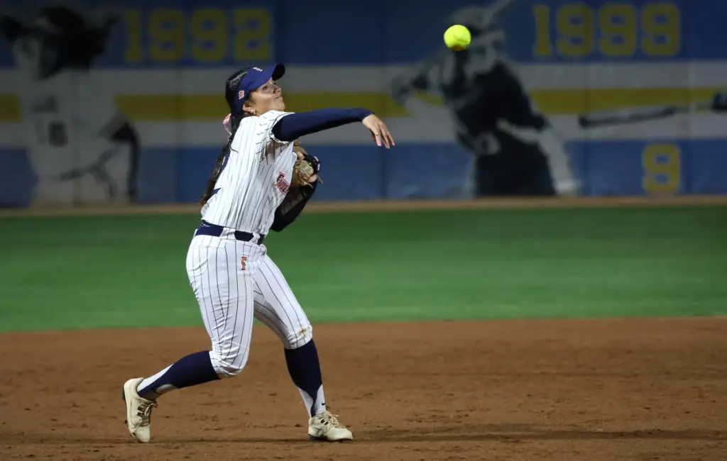 Cal State Fullertonâs Sarah Coccillos tosses the ball to first...