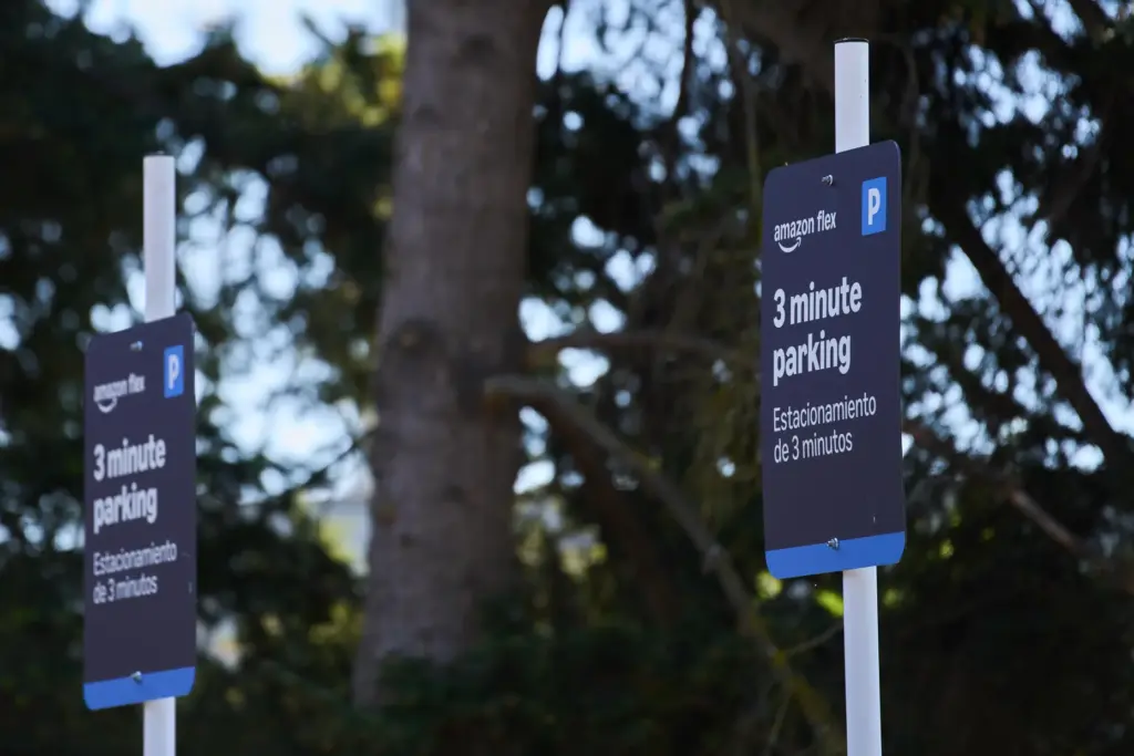 Parking signage for drivers stands outside an Amazon Now location.