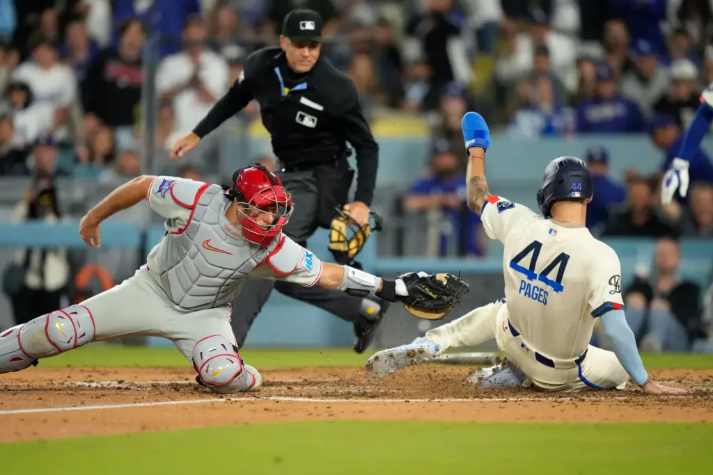 Dodgers’ Andy Pages, right, scores on a single by Mookie...