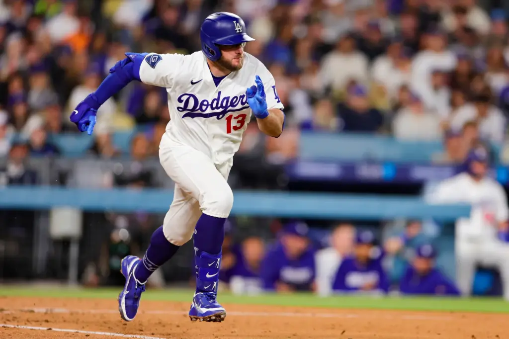 The Dodgers’ Max Muncy runs to first base after hitting...