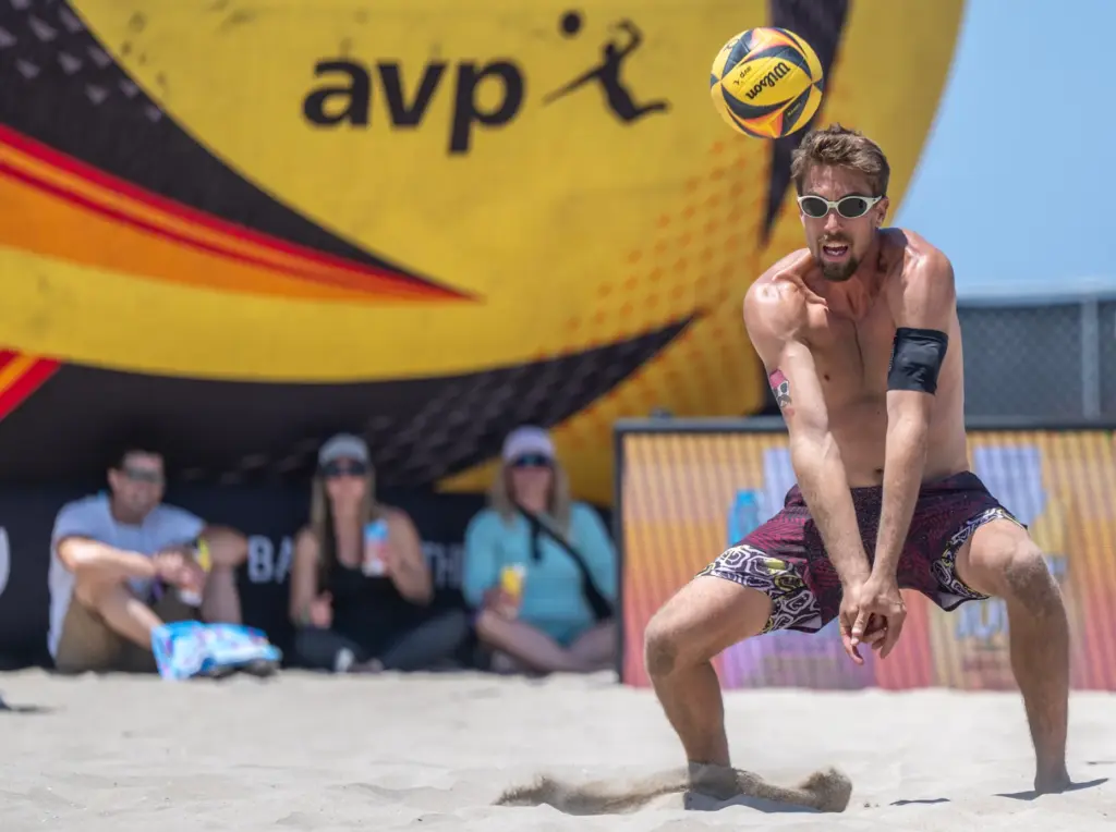 Taylor Crabb digs the ball, while playing with teammate Andy...