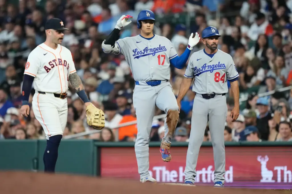 Dodgers star Shohei Ohtani, center, celebrates at first base after...