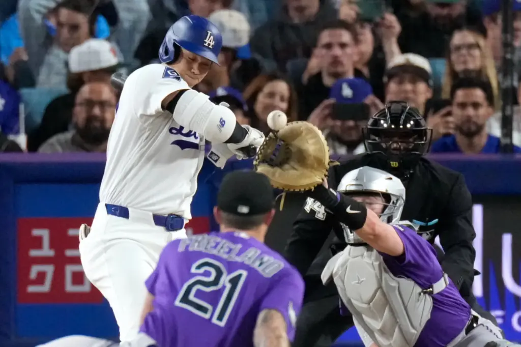 Dodgers star Shohei Ohtani, left, is hit on the hand...